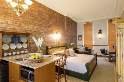 Kitchenette, cabinet with glassware, king bed & comfy sofa in King Superior Home Suite Home at Retro Suites Hotel