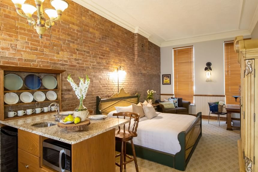 Kitchenette, cabinet with glassware, king bed & comfy sofa in King Superior Home Suite Home at Retro Suites Hotel