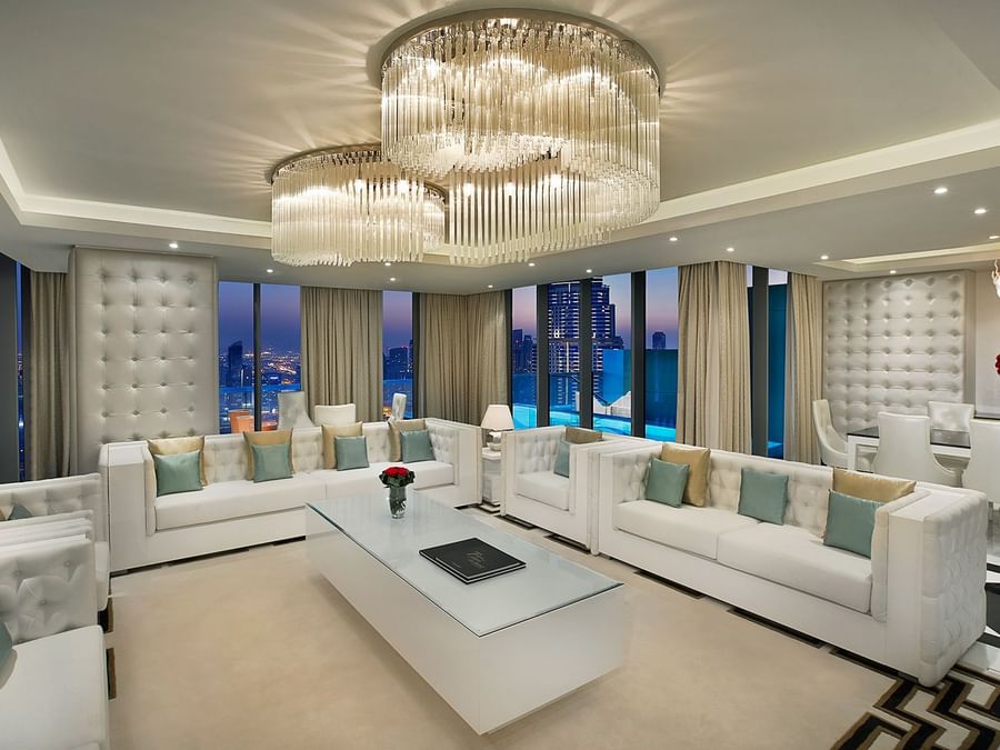 Penthouse living room with a large chandelier, sofas, and a city view at DAMAC Hotels & Resorts, One of the best apartment hotels in Dubai