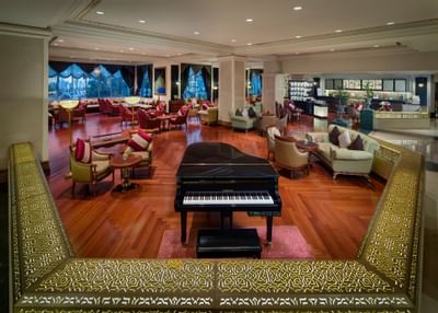 Lounge with a piano and sofas at Ajman Hotel