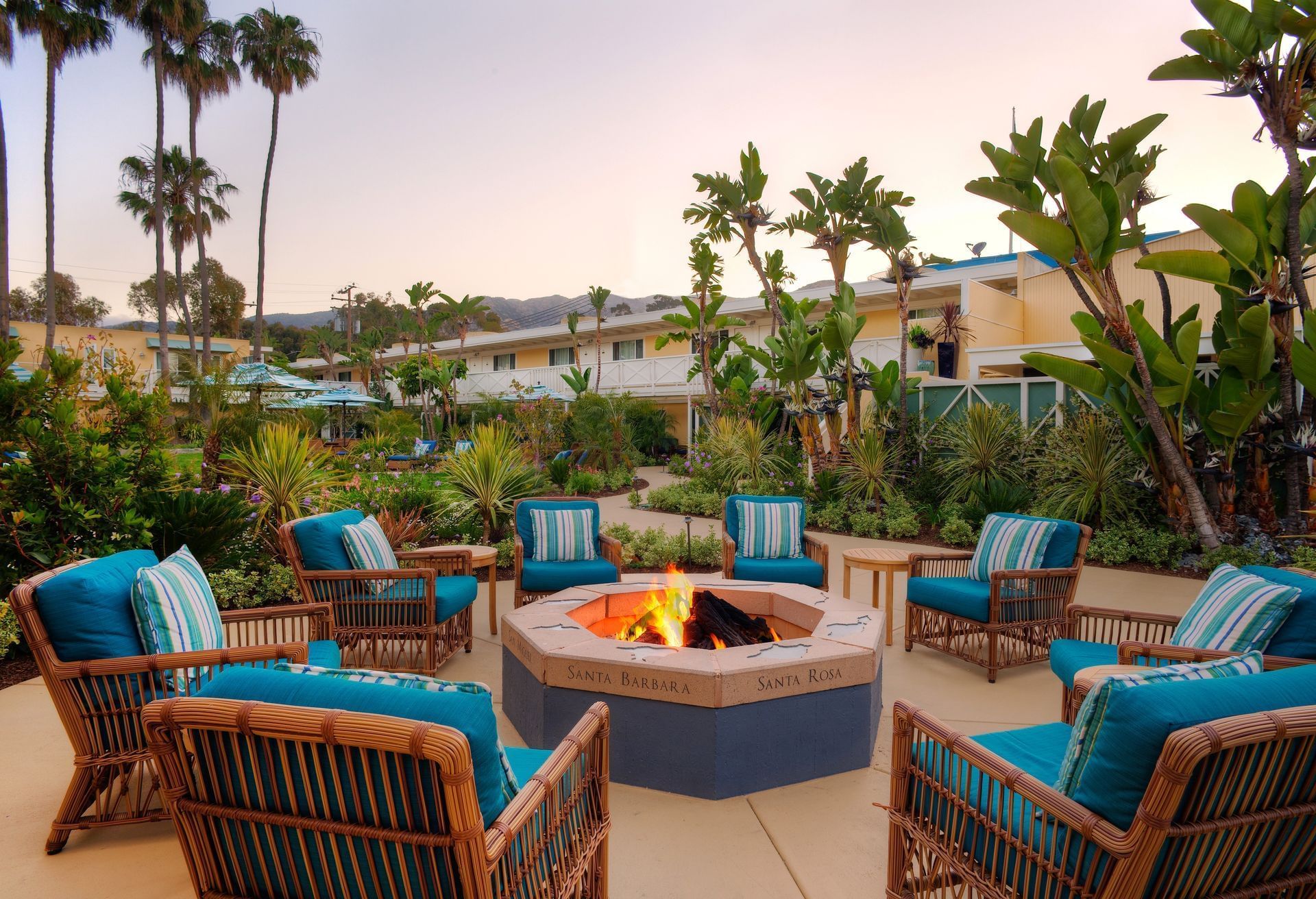 Outdoor lounge area with fire pit and tropical plants at Pavilion Hotel Catalina Island