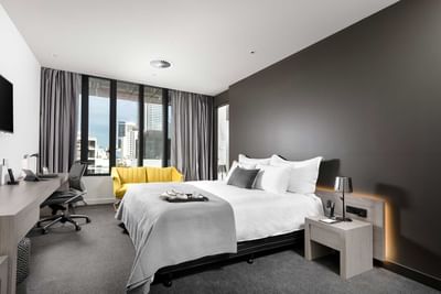 Work desk by the king bed in Premier Room City View at Melbourne Hotel Perth