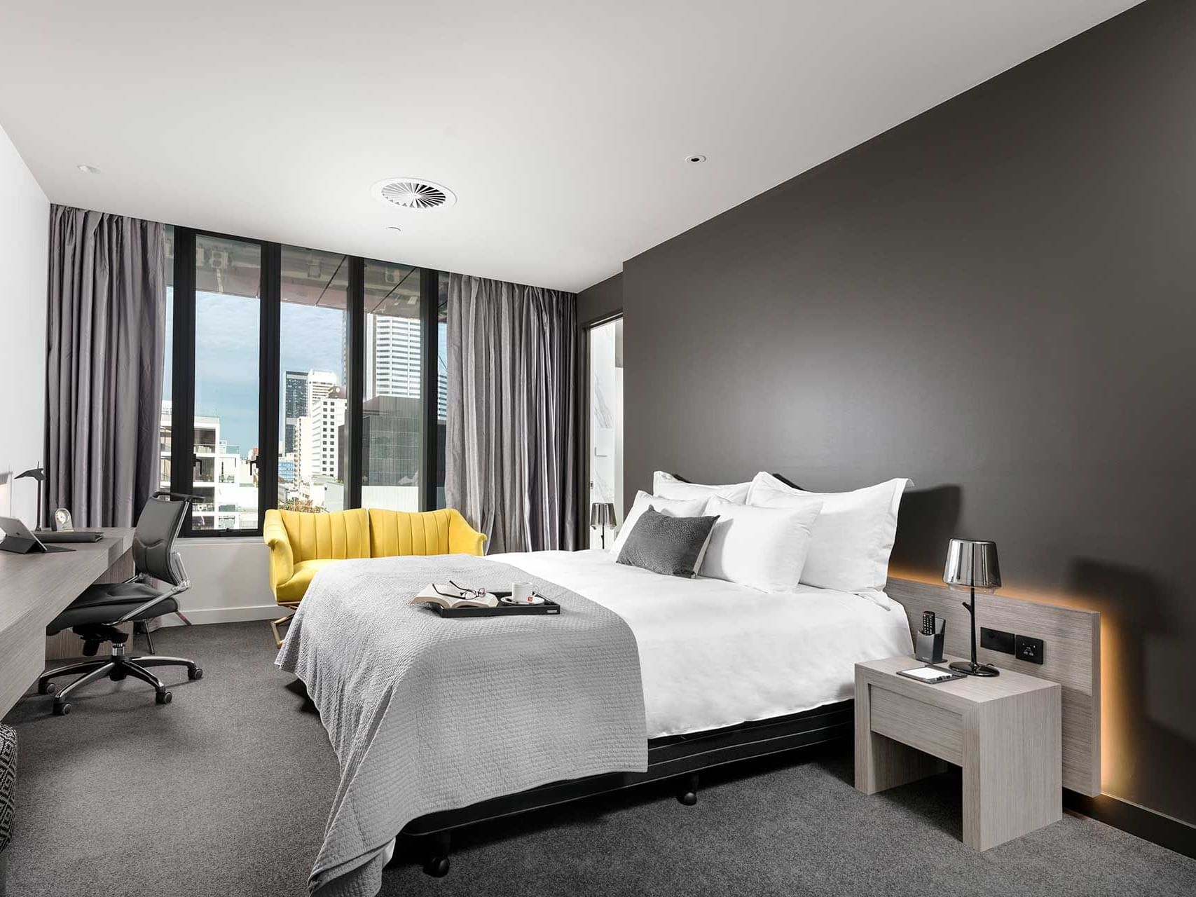 King bed and work area in Premier Room with city view at Melbourne Hotel Perth