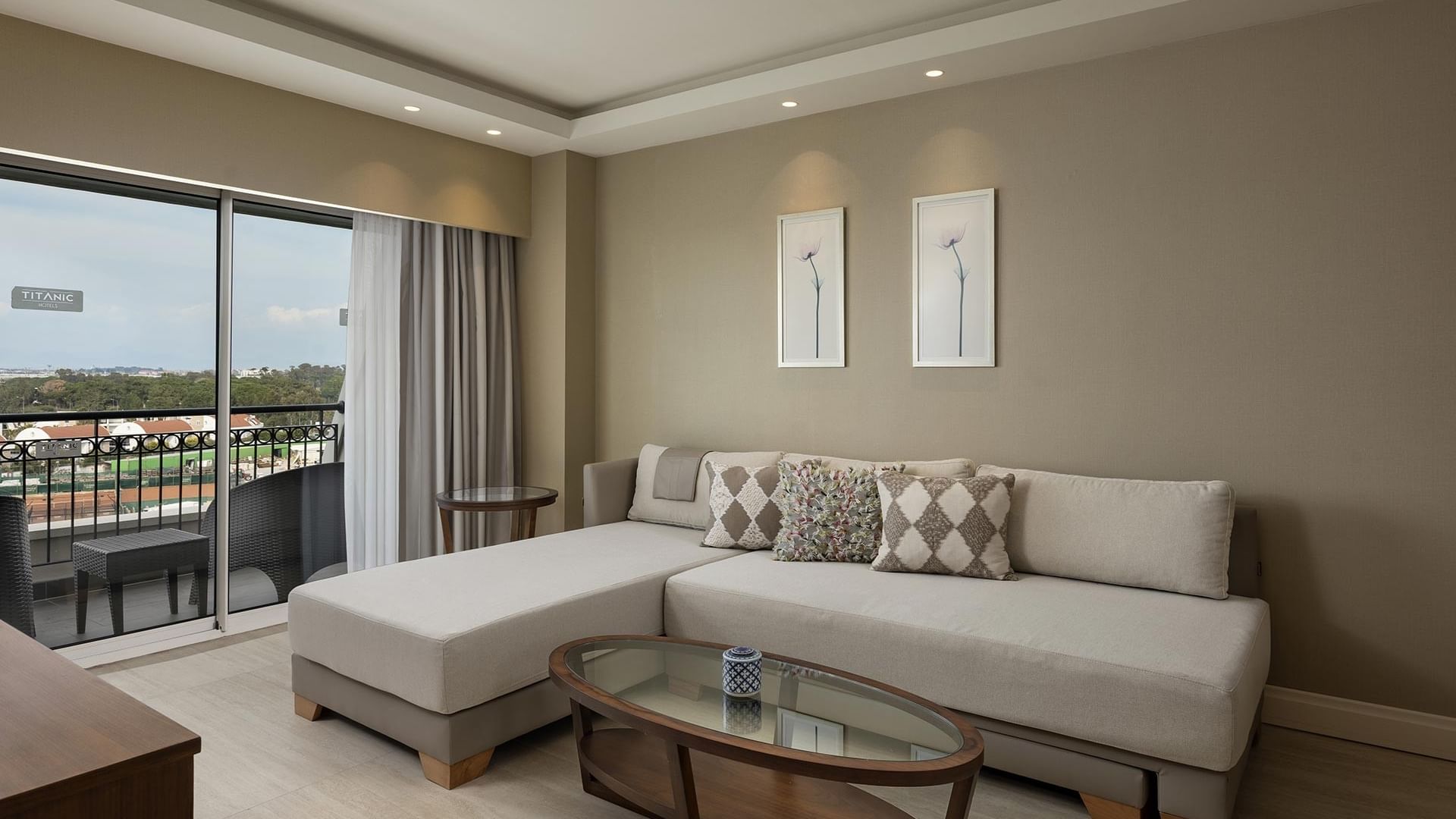 Deluxe room with couch, coffee table, and balcony view at Titanic Deluxe Golf Belek in Antalya.