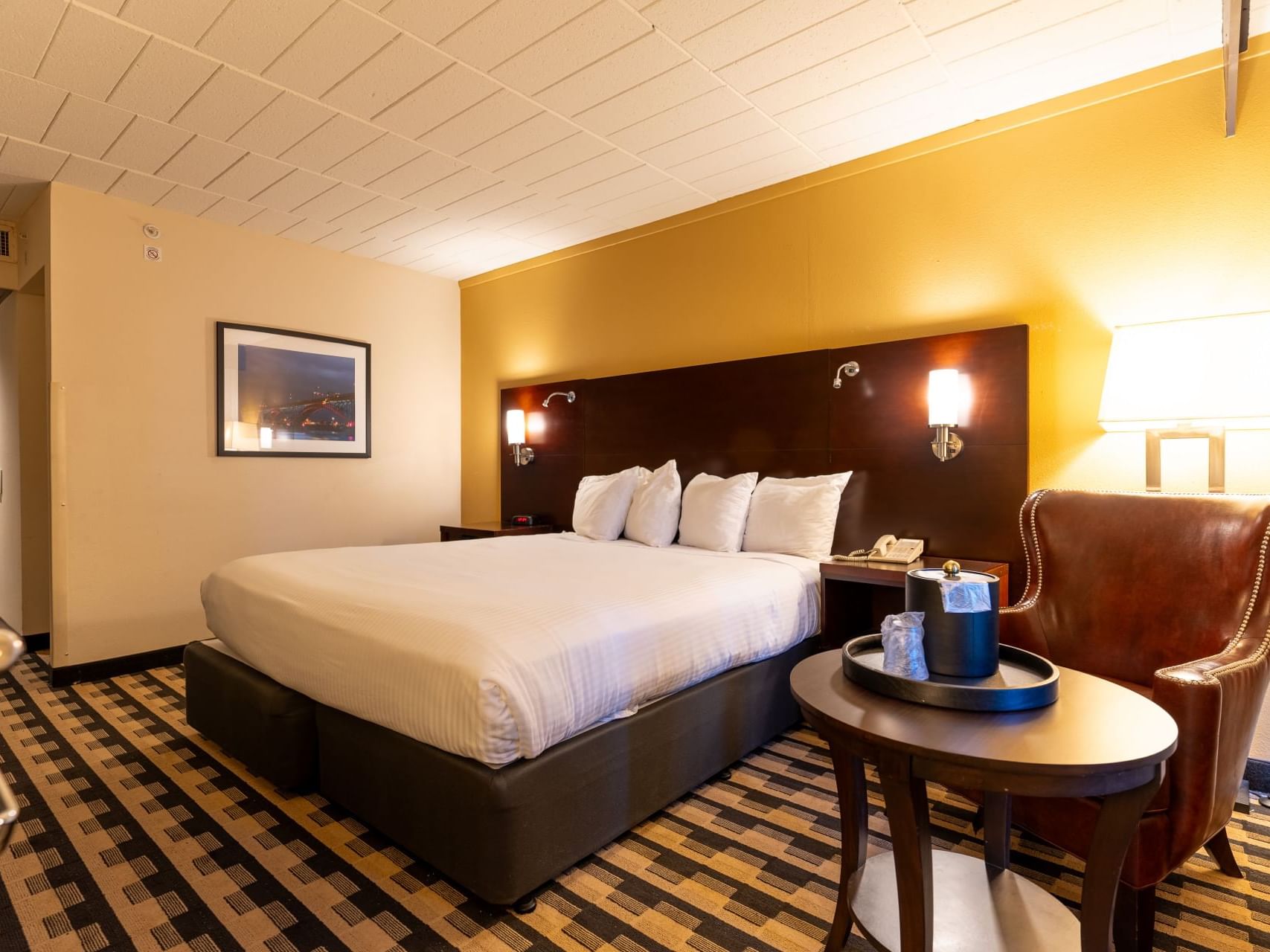 Lounge by the king bed in Classic King ADA Room with Roll-in Shower at M Hotel Buffalo