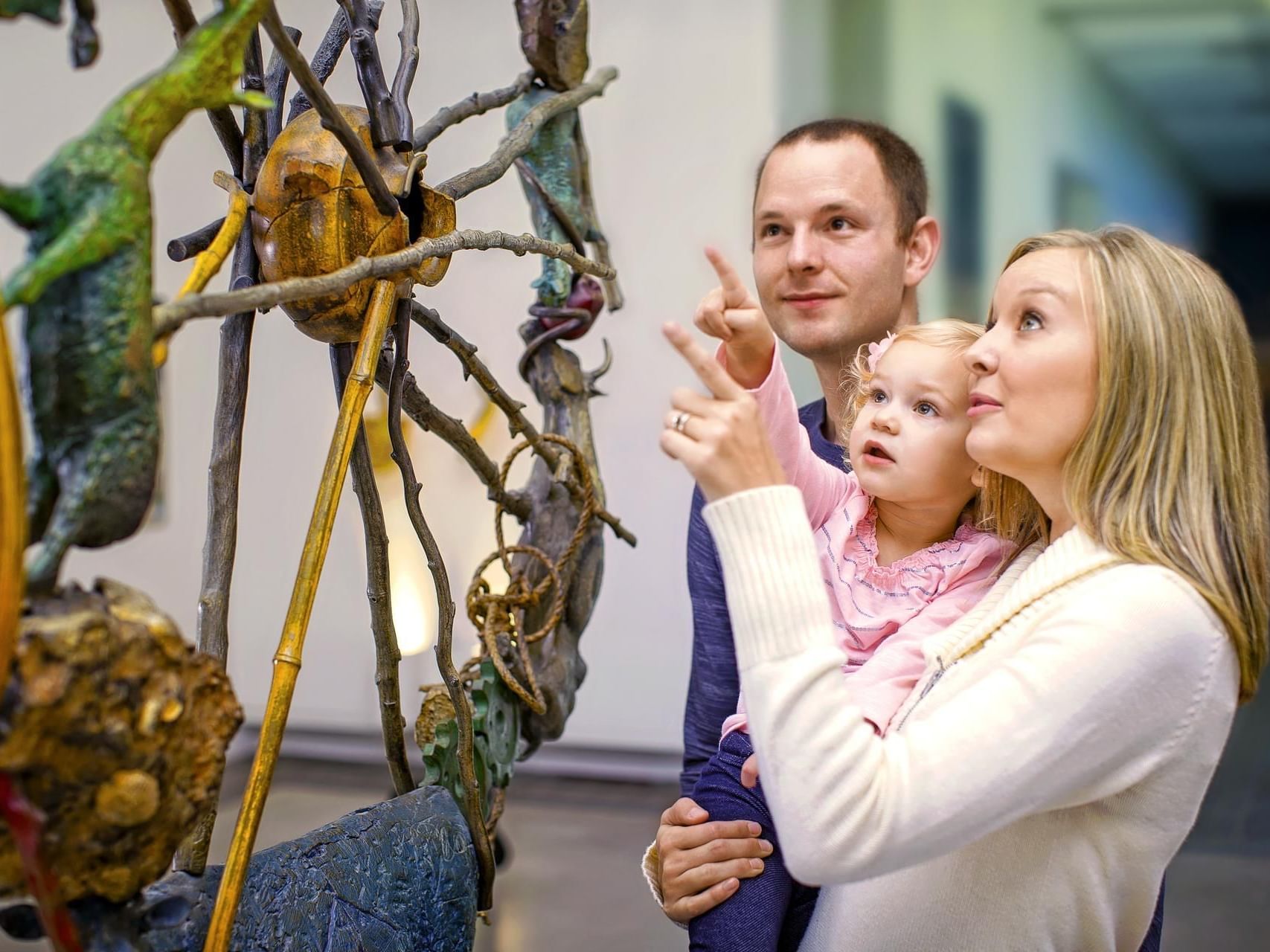 Family admiring a sculpture at Yellowstone Art Museum near Boothill Inn & Suites
