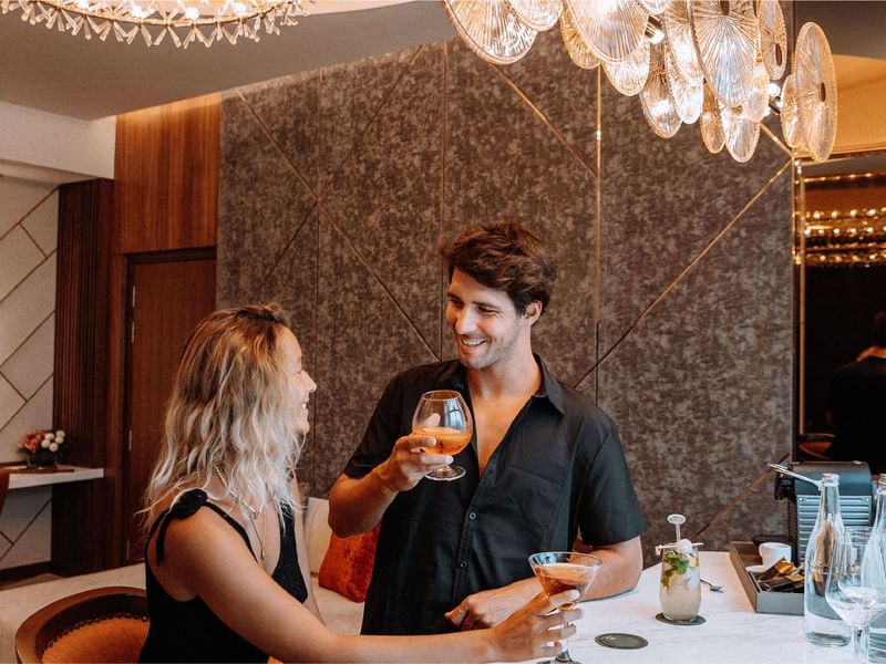 Smiling couple enjoying cocktails in a stylish suite at Sunway Resort