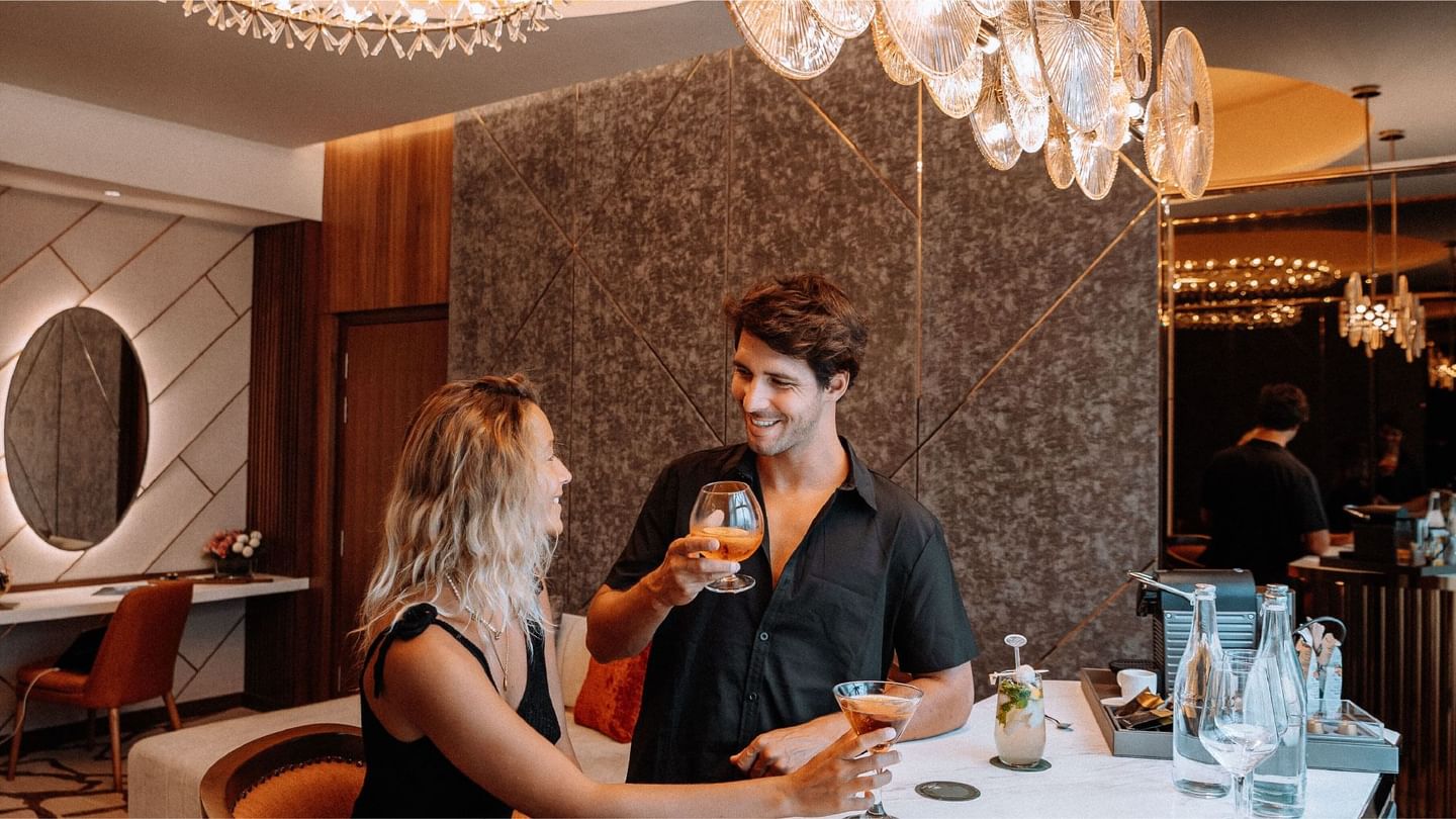 Smiling couple enjoying cocktails in a stylish suite at Sunway Resort