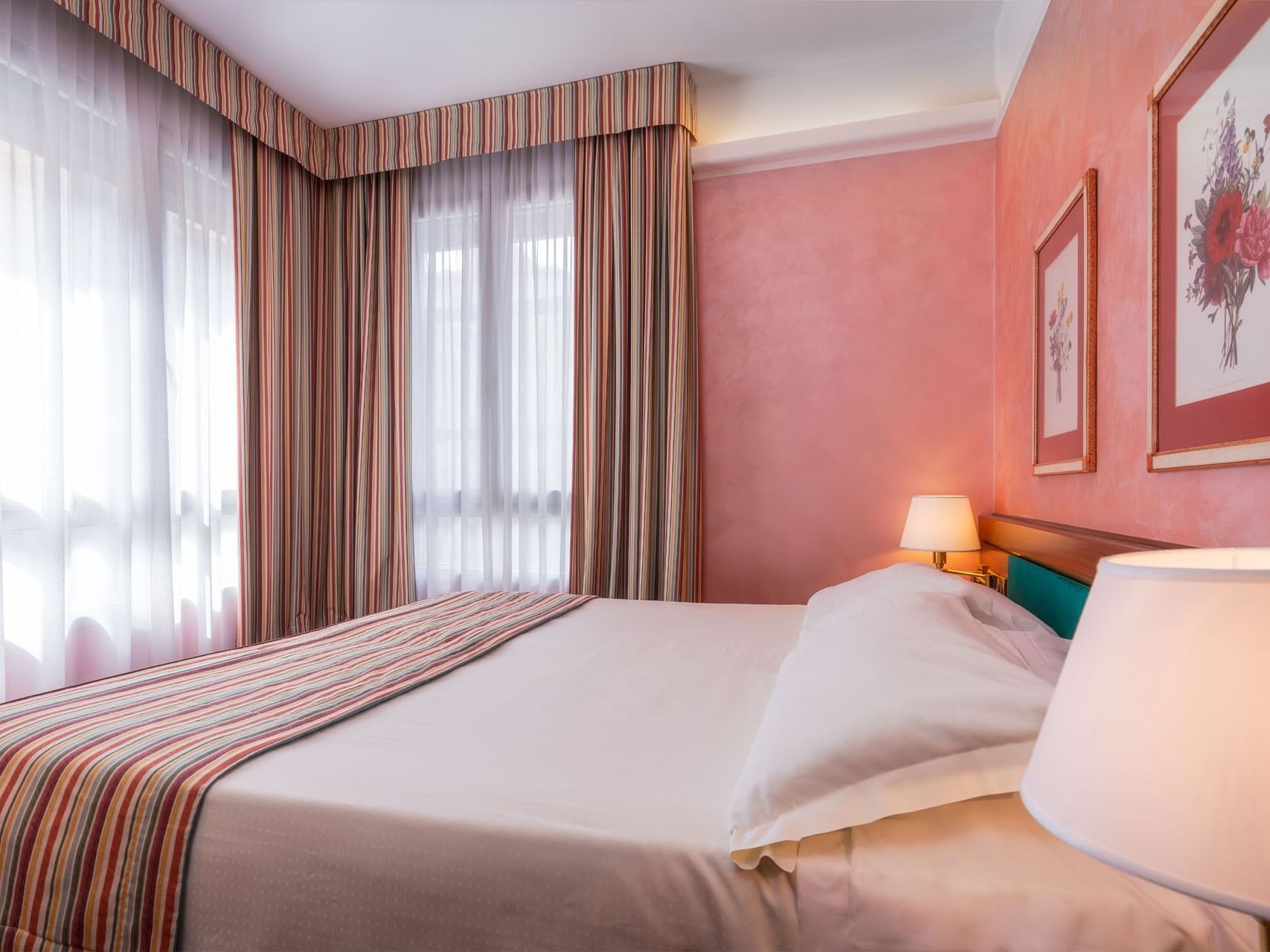 Cozy bed with nightstand & a view in Executive Suite at Hotel Crivi's in Milan