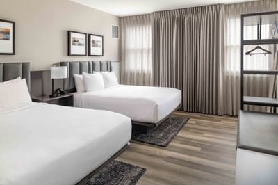 Two beds with cushioned headboards in a cozy room at Portland Harbor Hotel