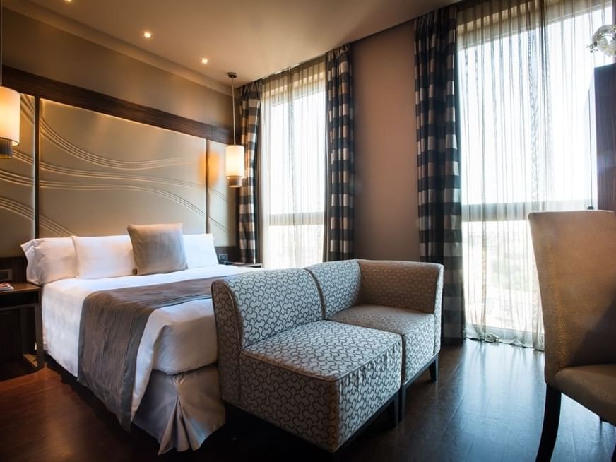Bed & furniture in Superior Queen Room at Uptown Palace