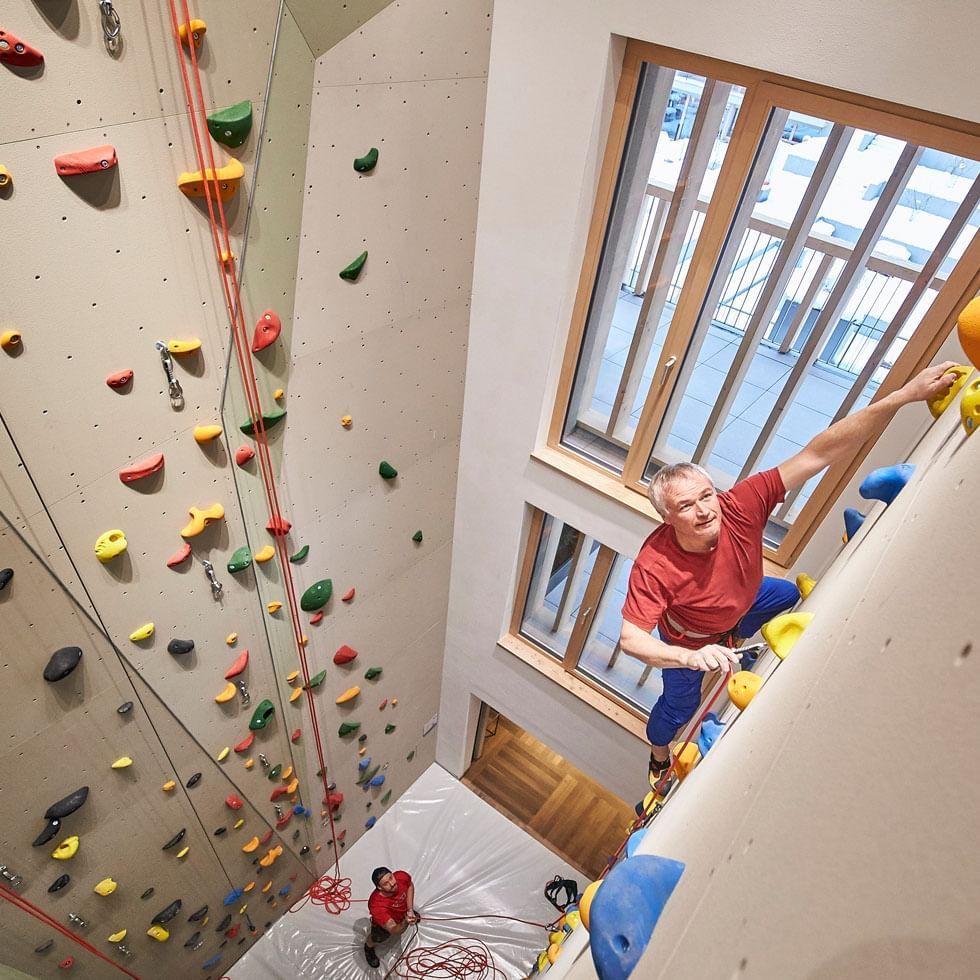 A man engaged in indoor wall climbing at Falkensteiner Hotels