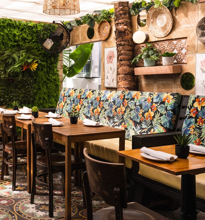 El Nogal restaurant at Riviera Hotel South Beach, featuring floral booths, woven wall decor, and intricate tiled floors