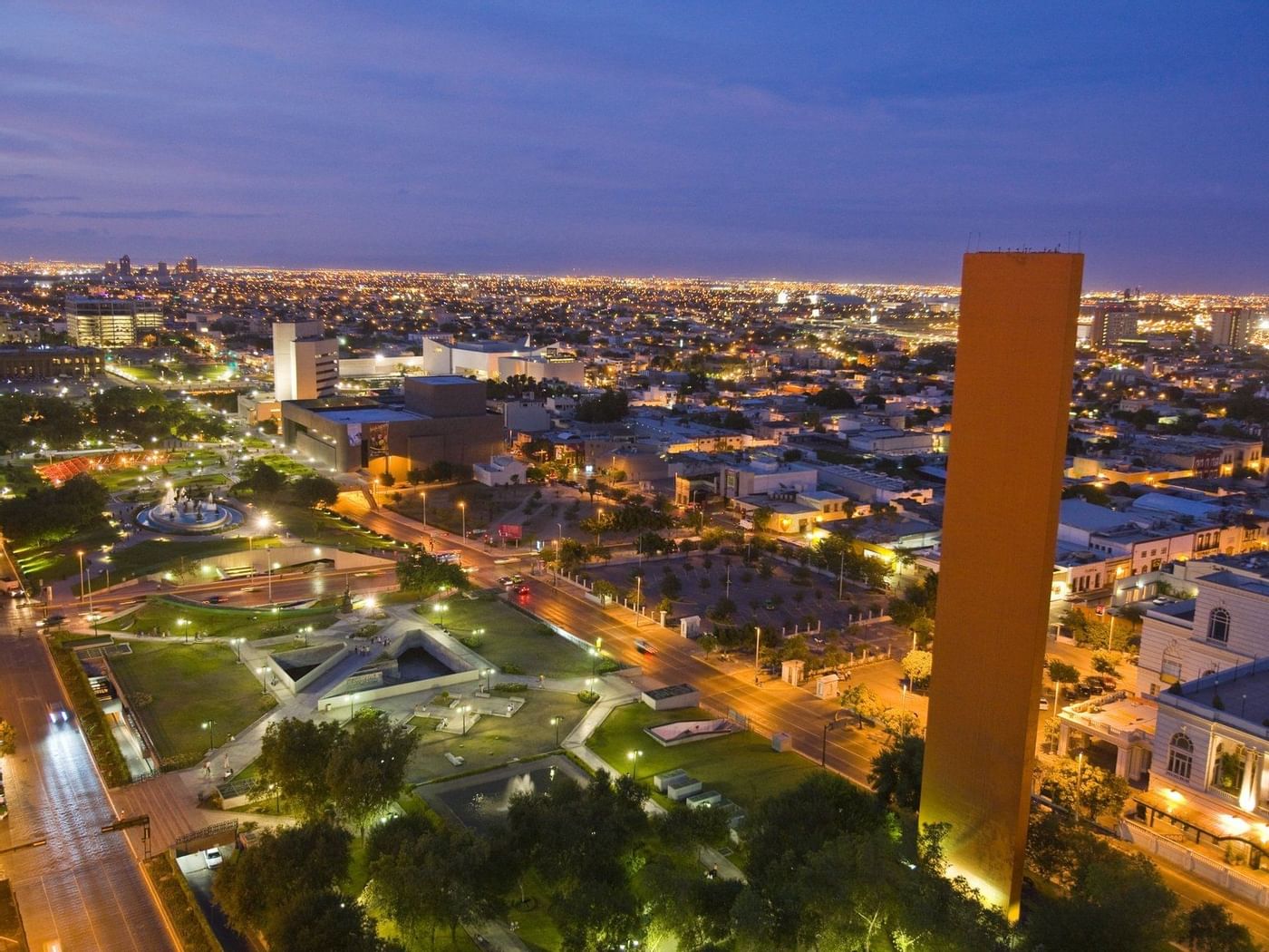 Aerial view of Macroplaza building near FA Hotels & Resorts at night
