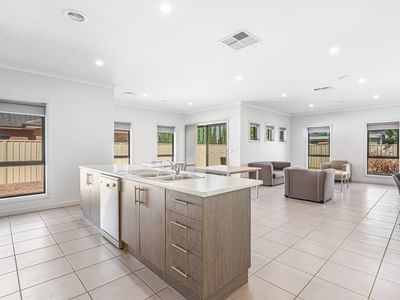 Brightly lit kitchen and living room area with modern furniture and appliances at La Trobe University Regional Housing – Mildura.