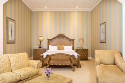 King bed, bedside cupboards with lamps, comfy sofas in King Executive King William at Retro Suites Hotel