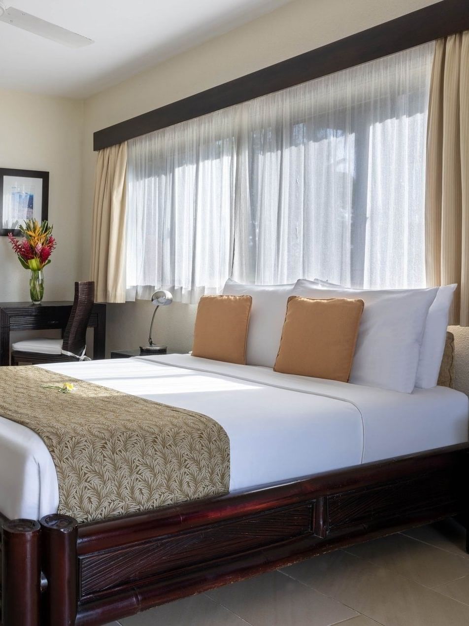 Comfortable bed and separate single bed beside small working area in Lagoon View Room at warwick le lagon-vanuatu