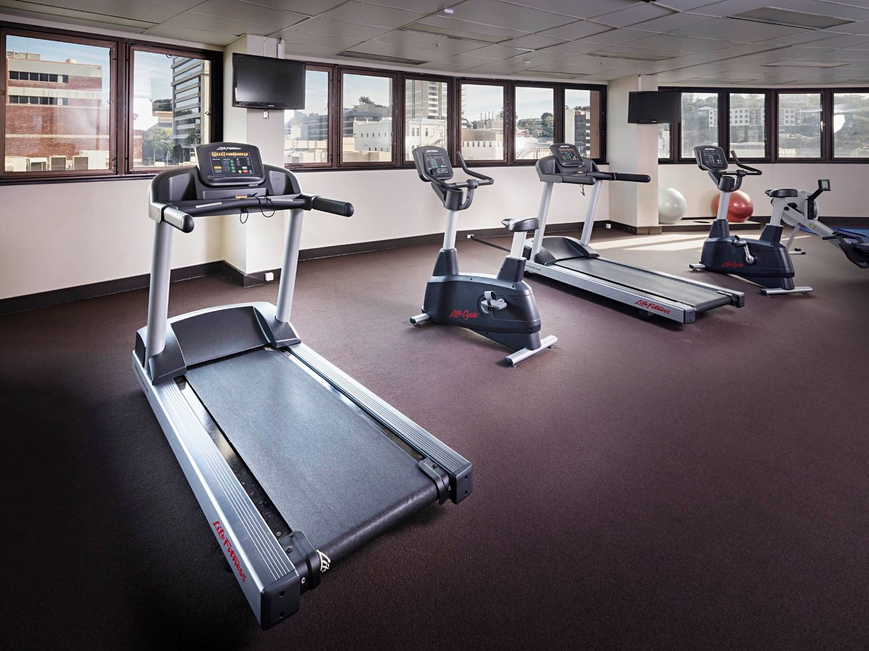 Exercise machines in the Gym with a city view at Hotel Grand Chancellor Townsville