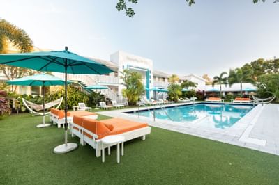 Image of the pool, pool deck with beds, chaise lounges and open 
