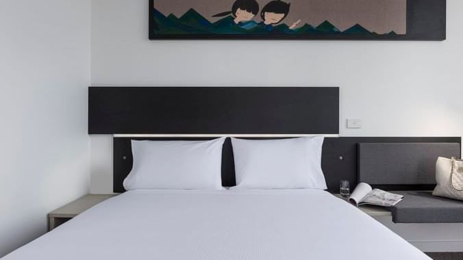 Cozy bed with hanging wall art in Standard Room, One Queen Bed at Ibis Adelaide