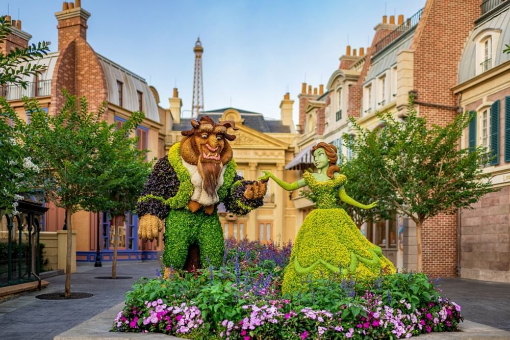 Topiary figures of Beauty and the Beast amidst a Parisian street scene at EPCOT, whose International Flower and Garden Festival happens every spring at Disney.