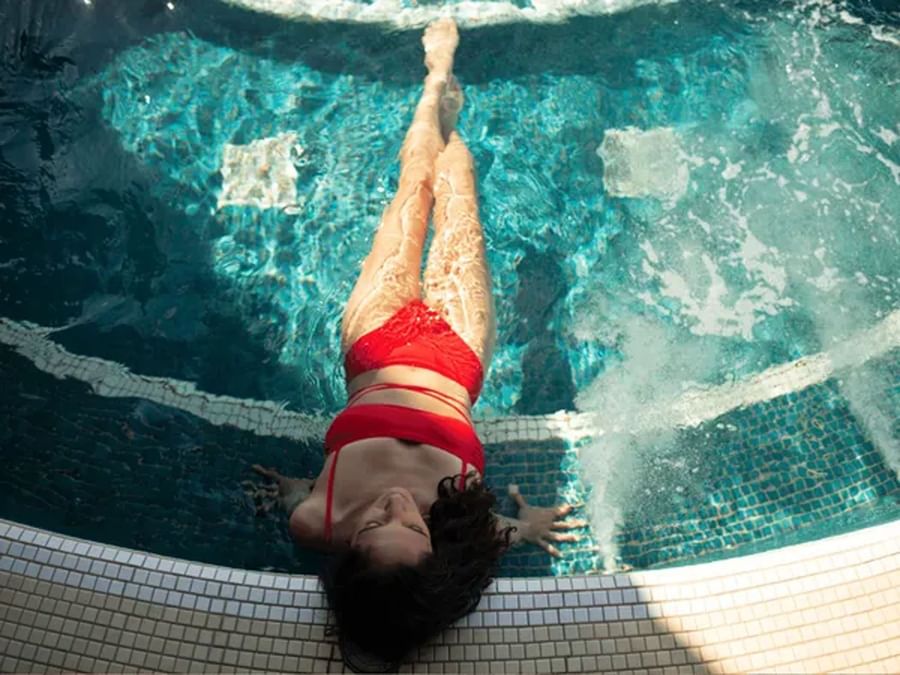 Close-up of a woman relaxing in the rooftop hot tub with clear water at Warwick Le Crystal Montreal