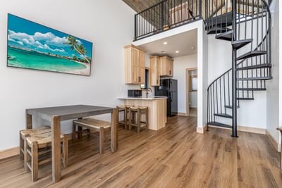 Modern kitchen with wooden flooring, dining area, and a spiral staircase in the villa at Off Shore Resort
