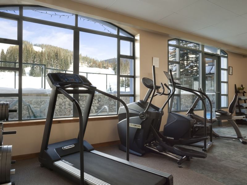 Treadmills in gym overlooking ski slopes