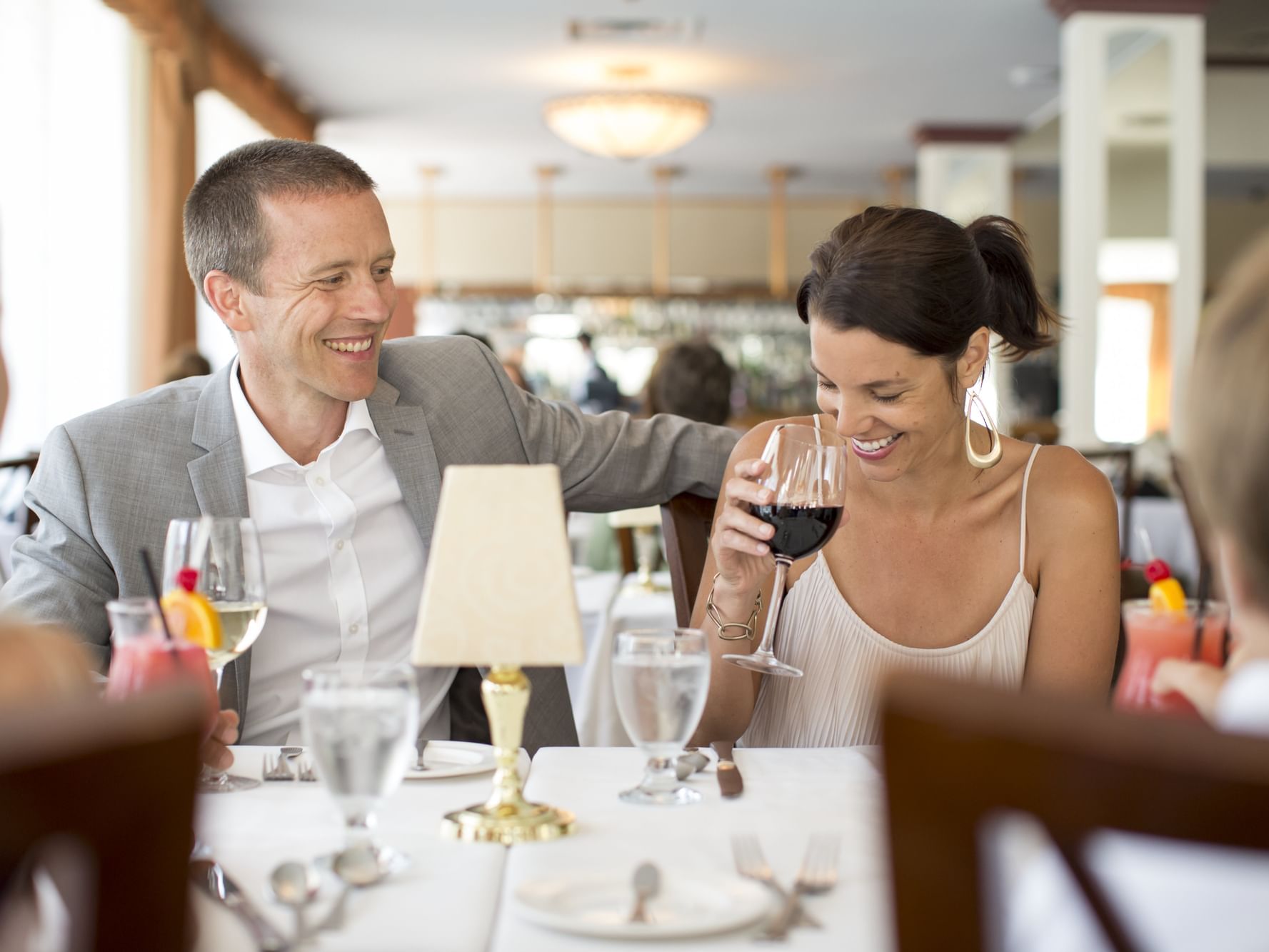 man and woman laughing and drinking wine