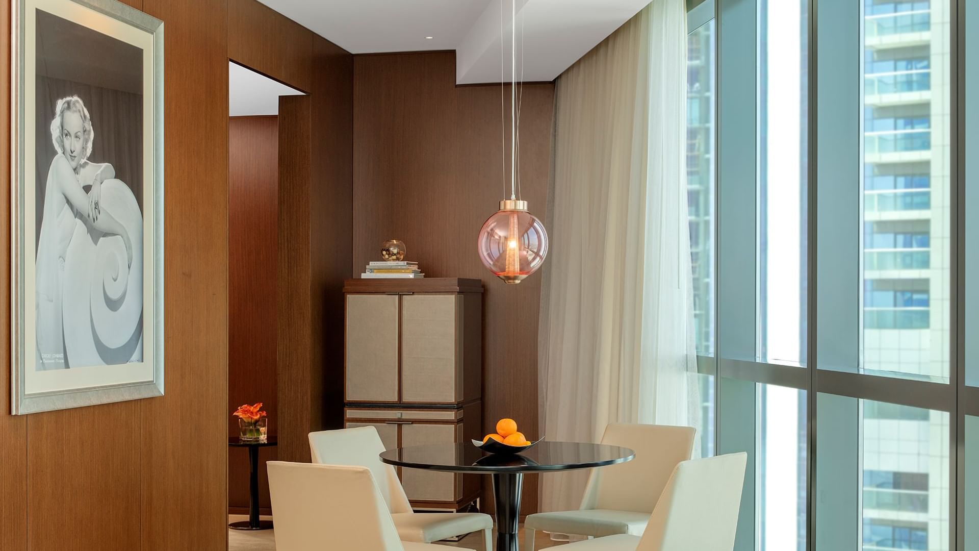 Dining area with a round table by the large window in Premier Suite with Panoramic View at Paramount Hotel Dubai