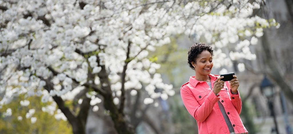 woman taking a selfie under cherry blossoms
