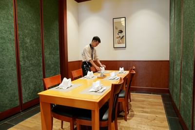 Waiter by a Restaurant dining table at Hanoi Daewoo Hotel