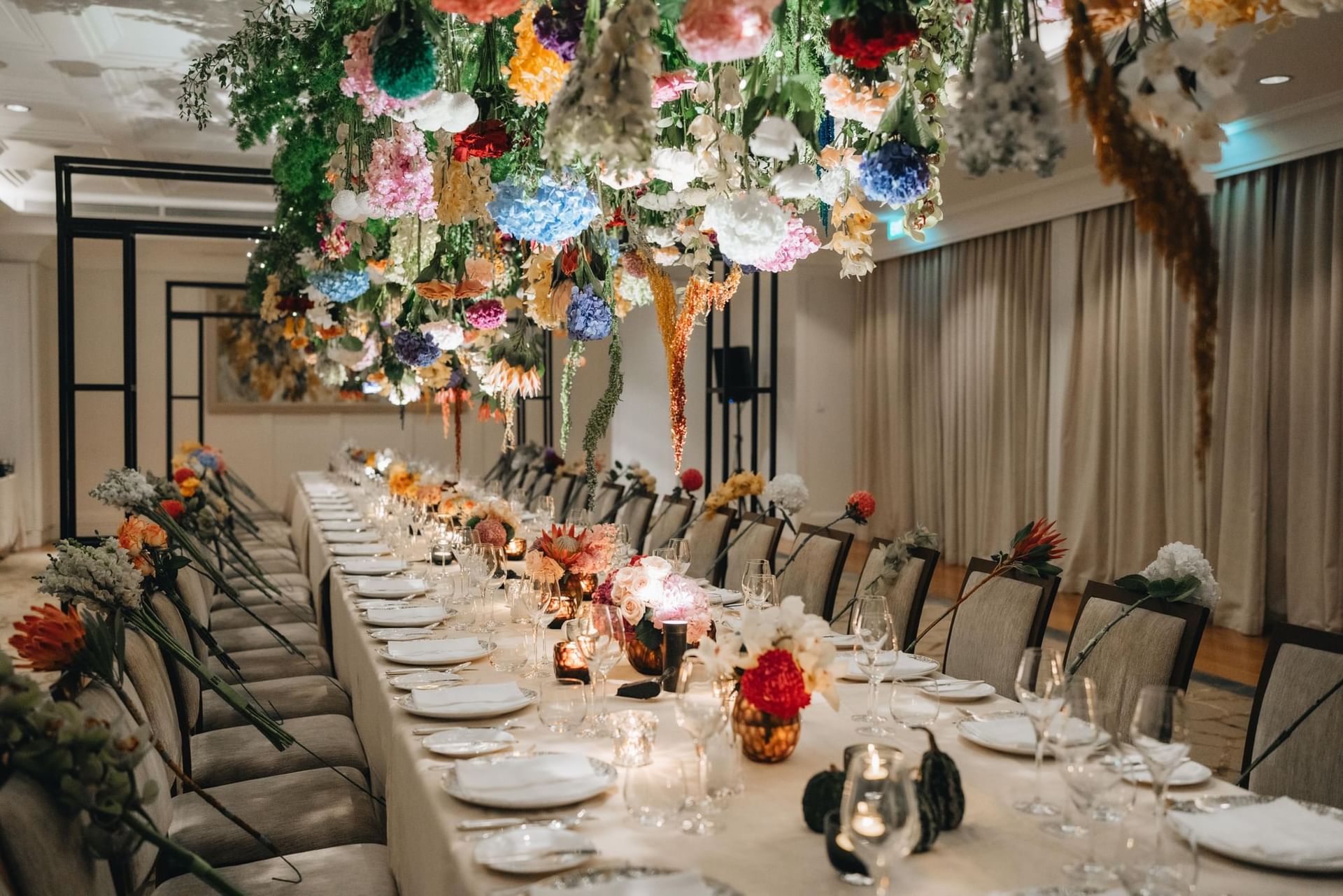 Beautifully decorated dining table with an overhead arrangement of colorful flowers at Park Hyatt Saigon