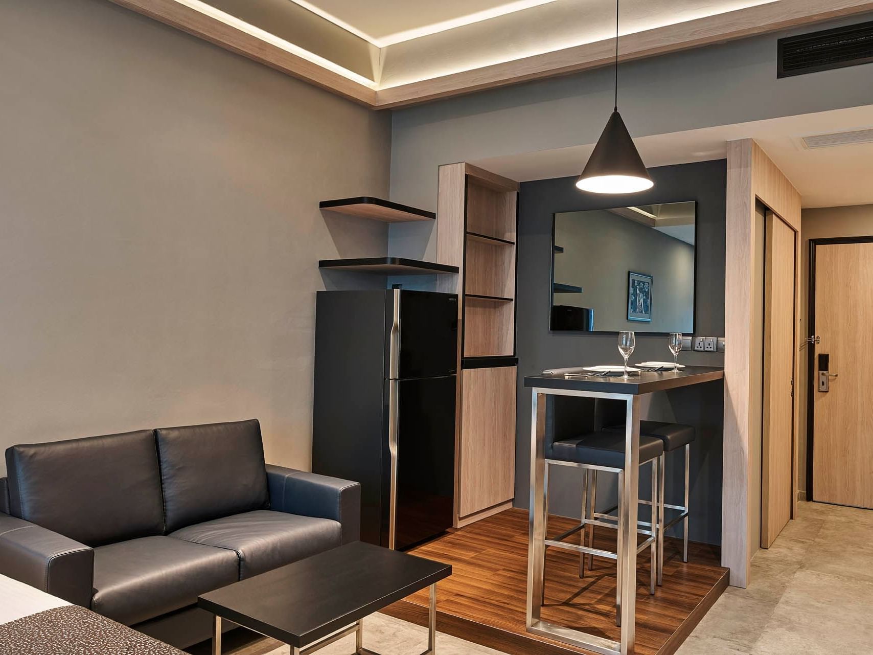 Image 13: Modern Studio Queen with leather sofa, kitchenette, fridge, and stylish bar seating at Orchard Grand Court