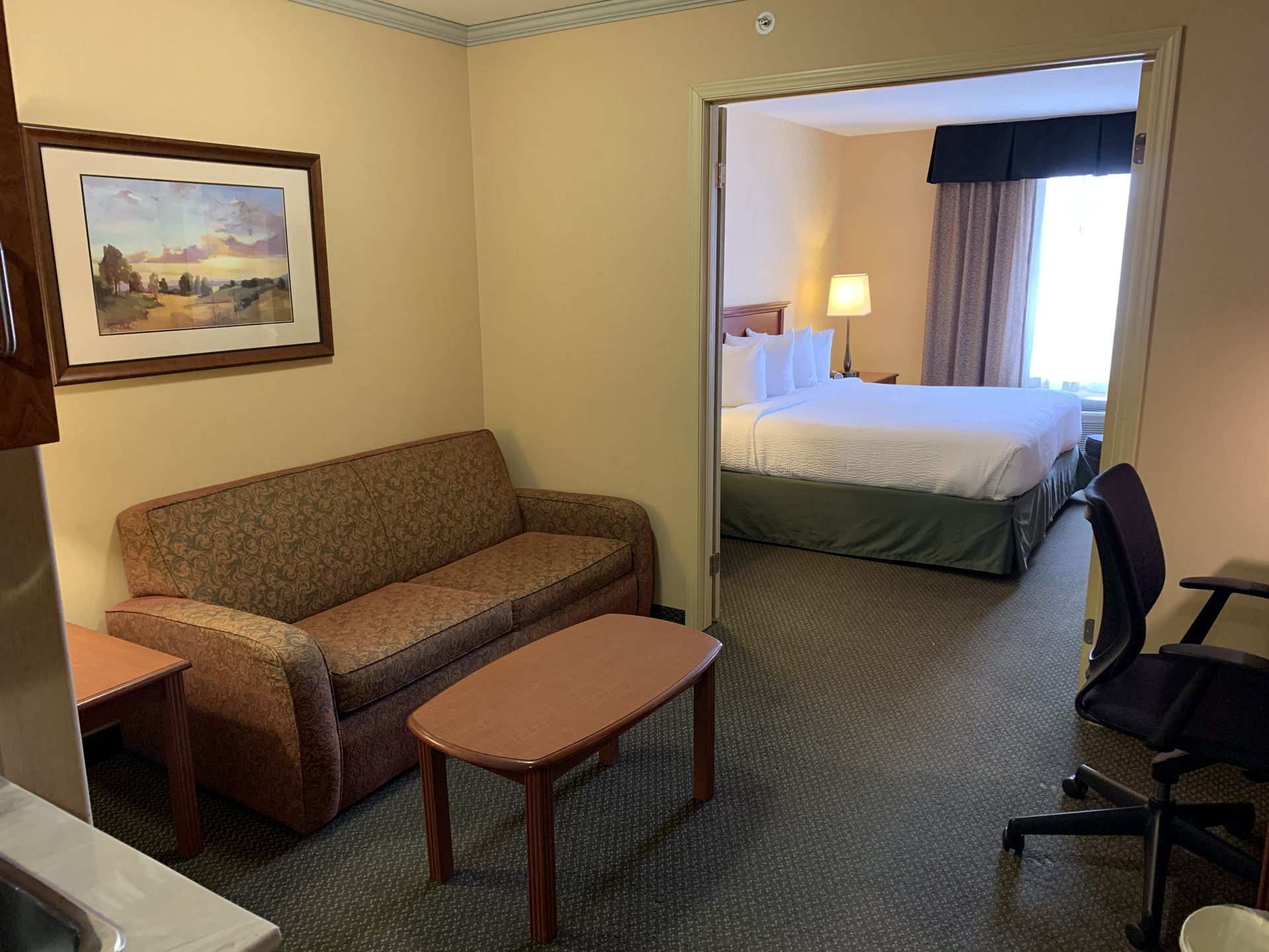 Lounge area in Business Suite - One King with carpeted floors at Merit Hotel & Suites, Fort McMurray hotels