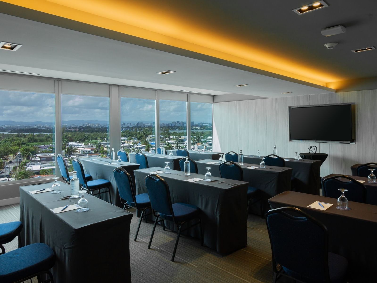 meeting room with rows of tables and chaird with television set up