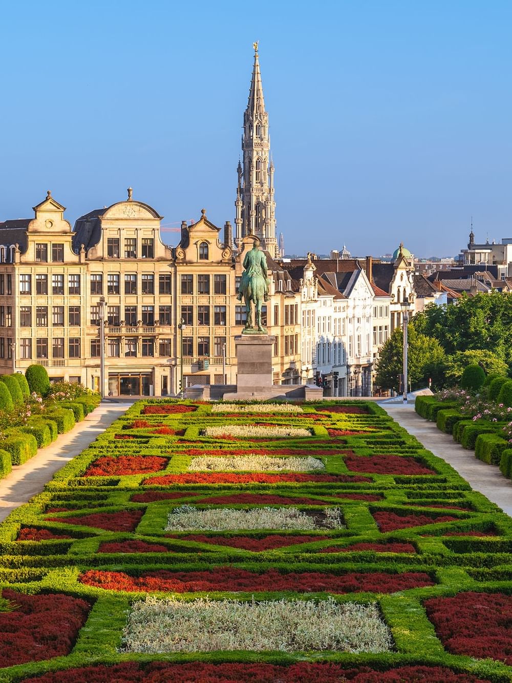 Historic square statue placed by a colorful garden path near Warwick Grand Place Brussels
