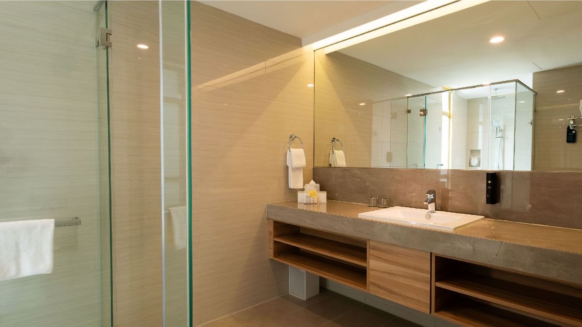 Modern and well-lit bathroom with a spacious vanity, large mirror, and glass shower at Sunway Lagoon Hotel