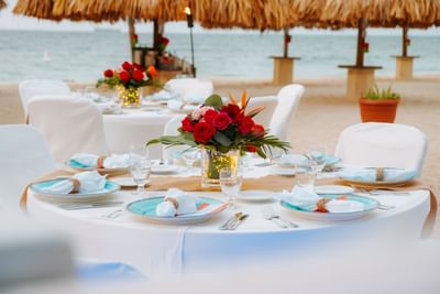 Beachside table arrangement with white linens & glassware at Amsterdam Manor Beach Resort