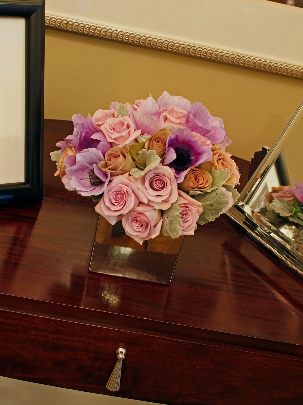 Floral arrangement with pink roses placed by a framed photo in Hollywood Suite at Warwick New York