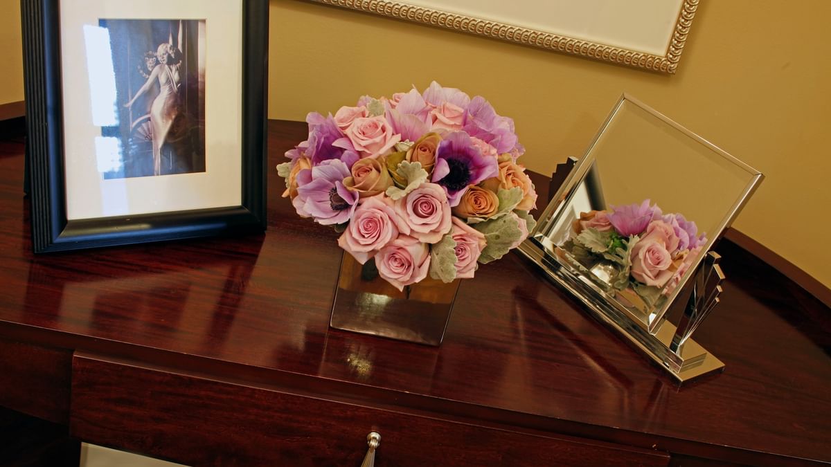 Flower arrangement and framed artwork on a table in the Hollywood Suite at Warwick New York
