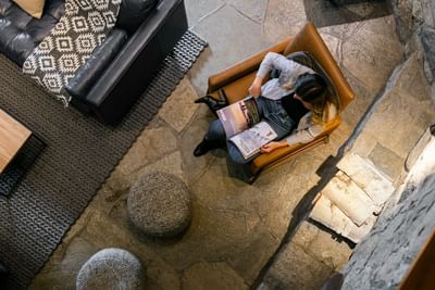 Overhead photo of woman reading in a cozy lobby at Adara Hotel