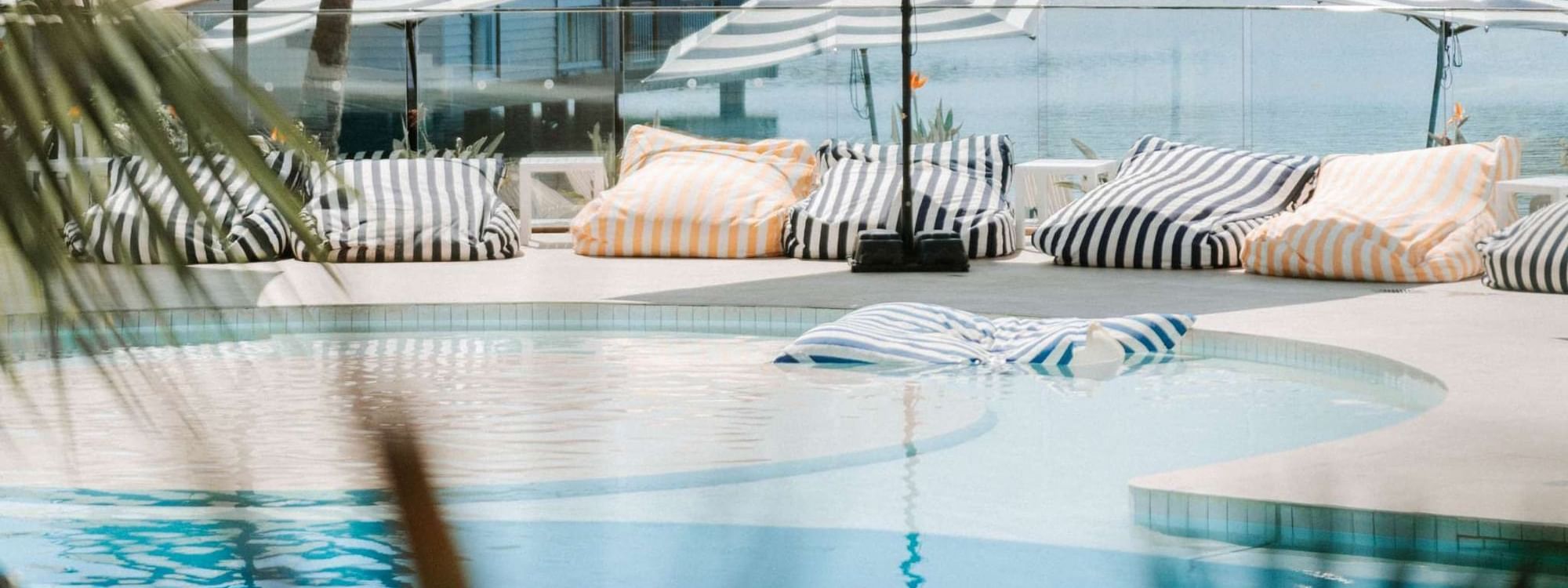 Lounge area with cozy pillows by the Resort pool at Novotel Sunshine Coast Resort