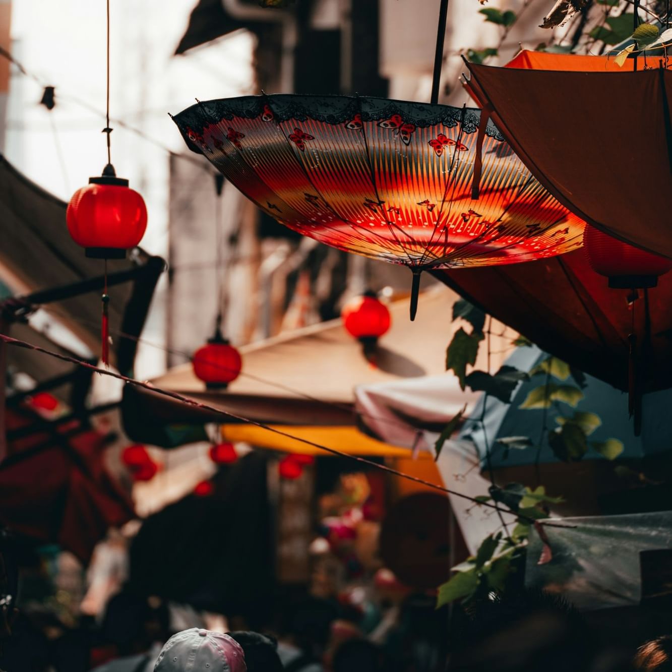 A decorative umbrella and lanterns hanging in a narrow alleyway near The Terraces Resort & Spa