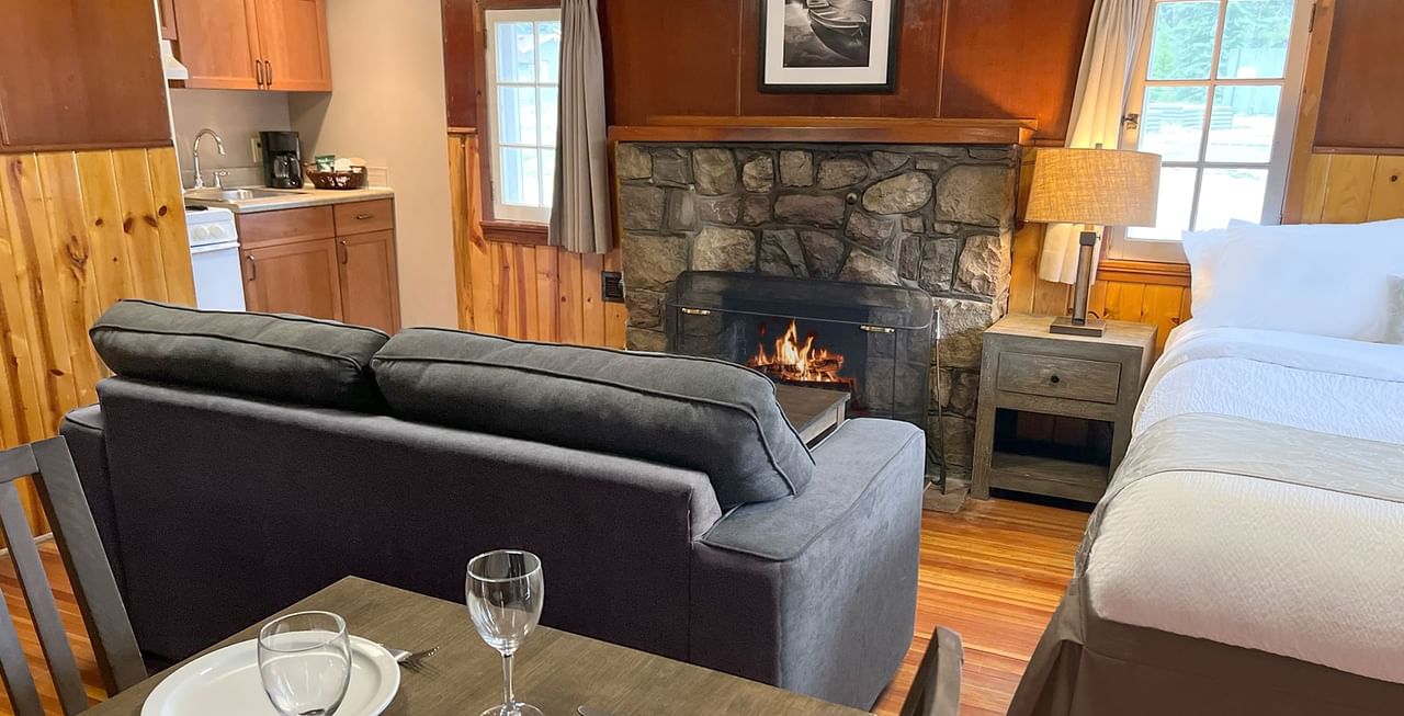 Interior of cabin with dining area, bed, sitting area, and kitchen