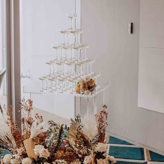 Champagne tower with beautiful flowers for wedding reception at magenta