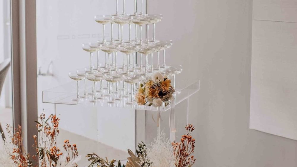 Champagne tower with beautiful flowers for wedding reception at magenta