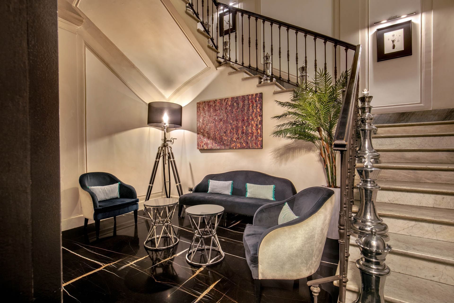 Cozy lobby featuring stylish sofa with glass tables by the floor lamp and art on the wall at The Glam Hotel