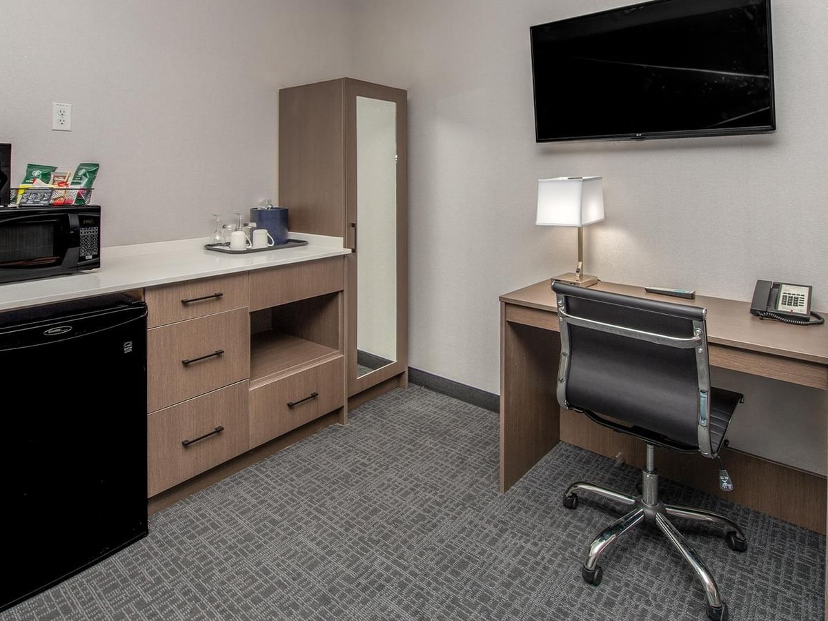 Room with work desk, TV, fridge, and microwave