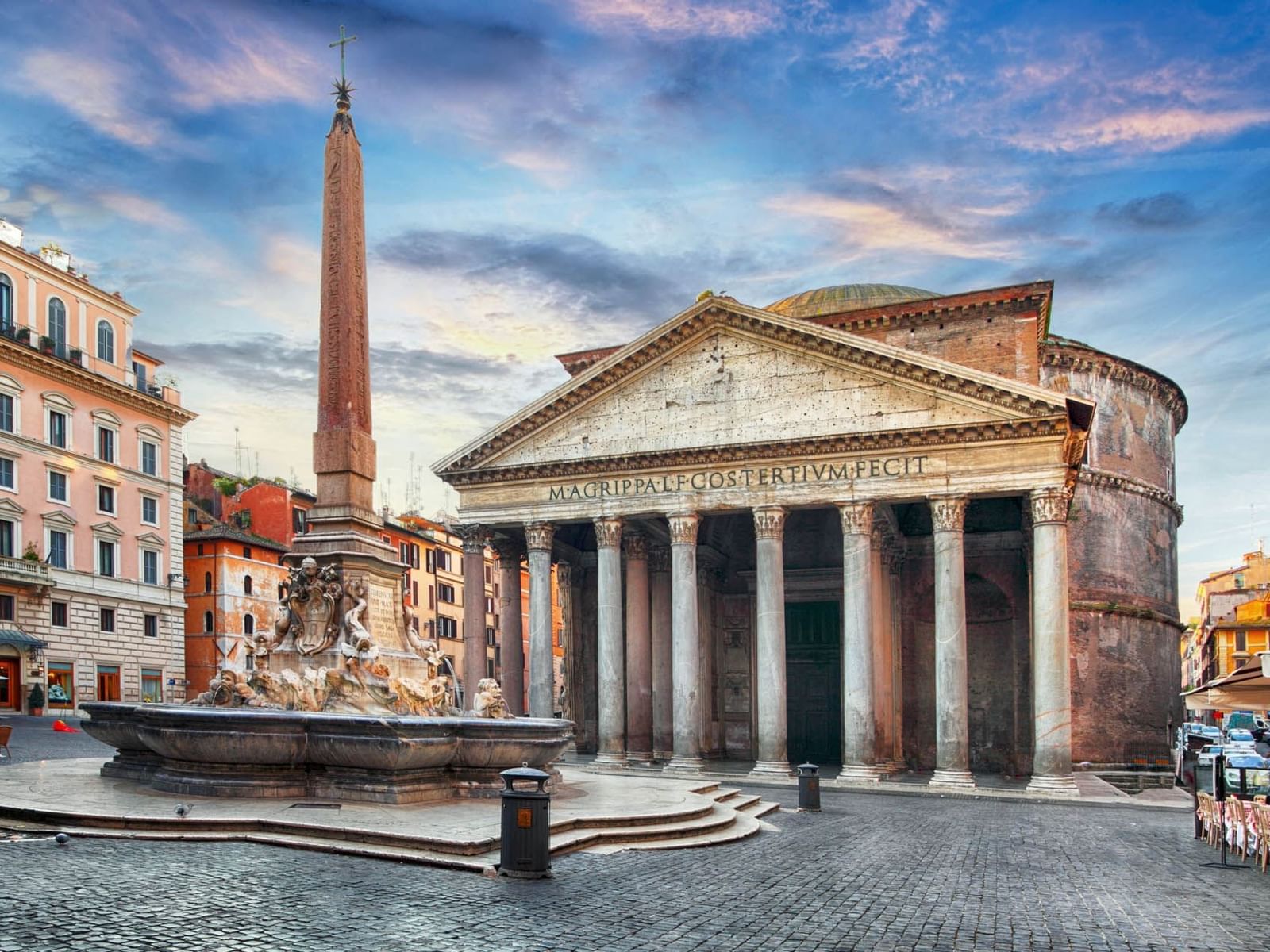 Pantheon with classical columns, a tall obelisk, and a decorative fountain near The Guardian Hotel